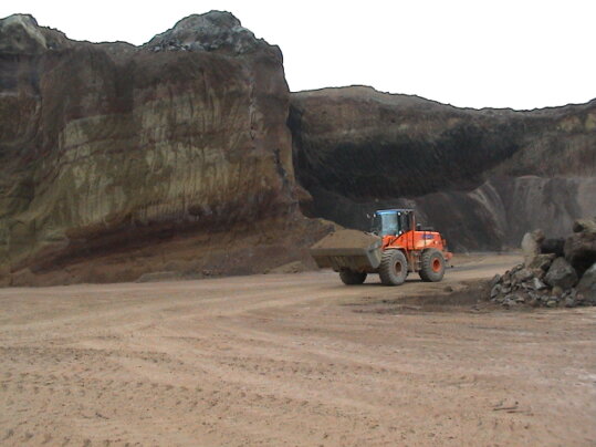 Escavatore e dumper durante l’estrazione del lapillo